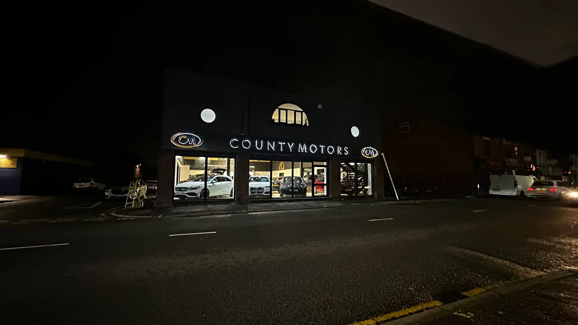 County Motors illuminated frontage photographed at night